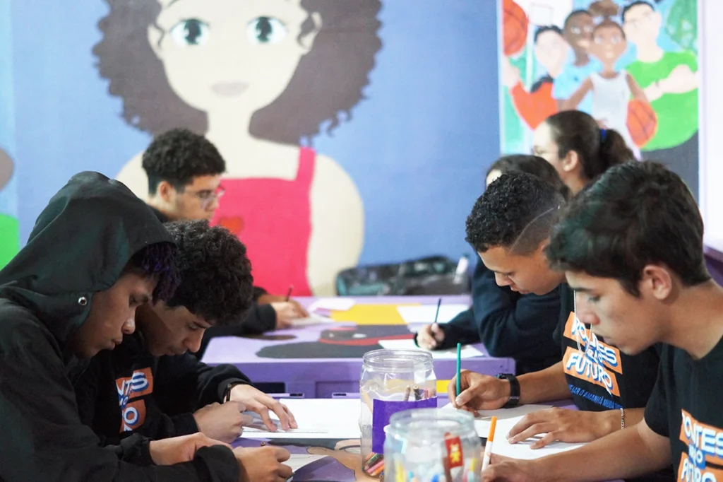 Jovens concentrados em atividade de desenho no Projeto Pontes para o Futuro