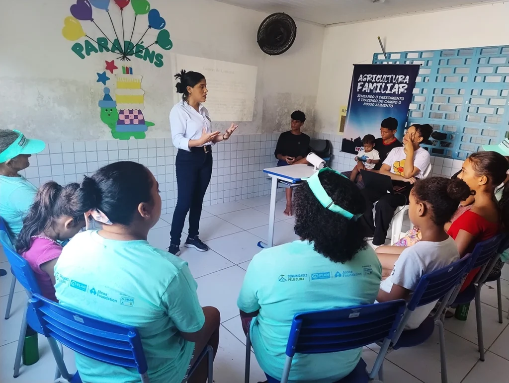 Educadora conduzindo oficina sobre agricultura familiar e mudanças climáticas com moradores e crianças no Projeto Comunidades Pelo Clima.
