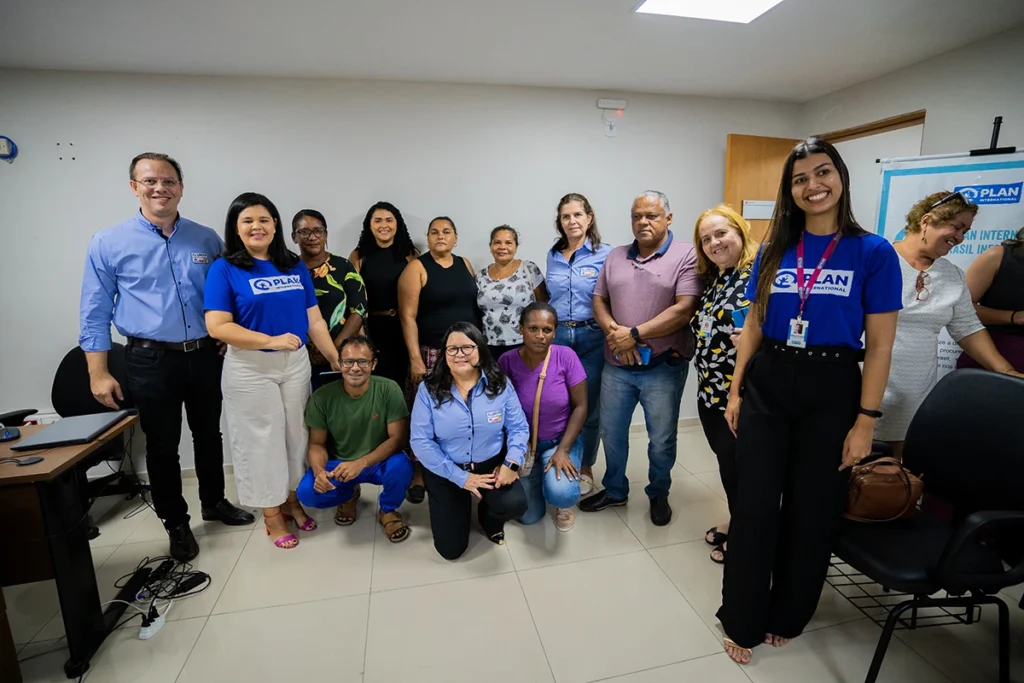 Grupo de adultos participantes do Projeto Comunidades Pelo Clima da Plan International Brasil em reunião de capacitação sobre preservação ambiental.